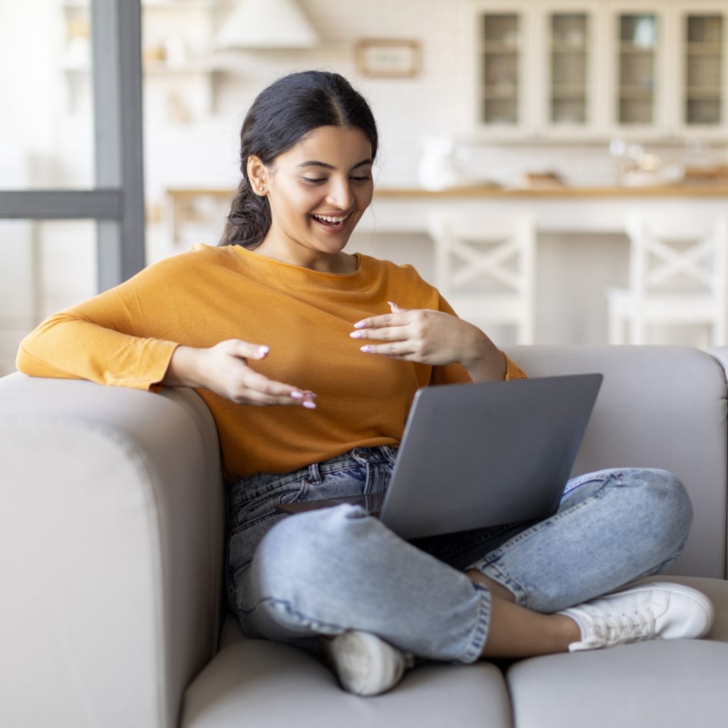 Woman sitting on couch with laptop